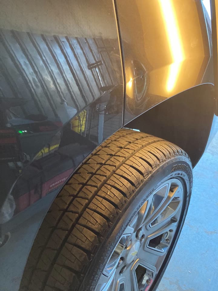 Before: dent on the rear quarter panel of a dark Chevrolet
